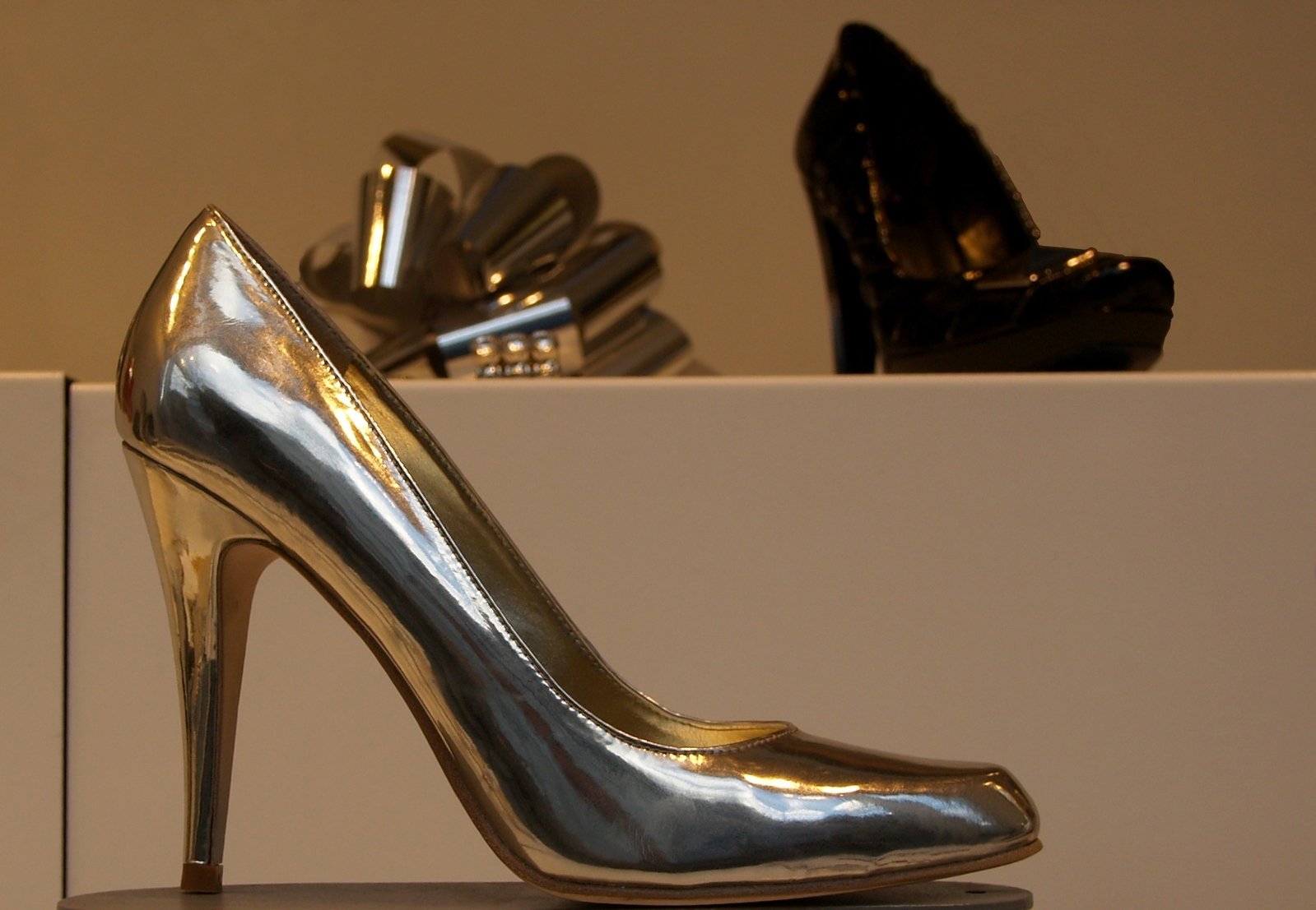a high heeled gold shoe sitting on a white counter