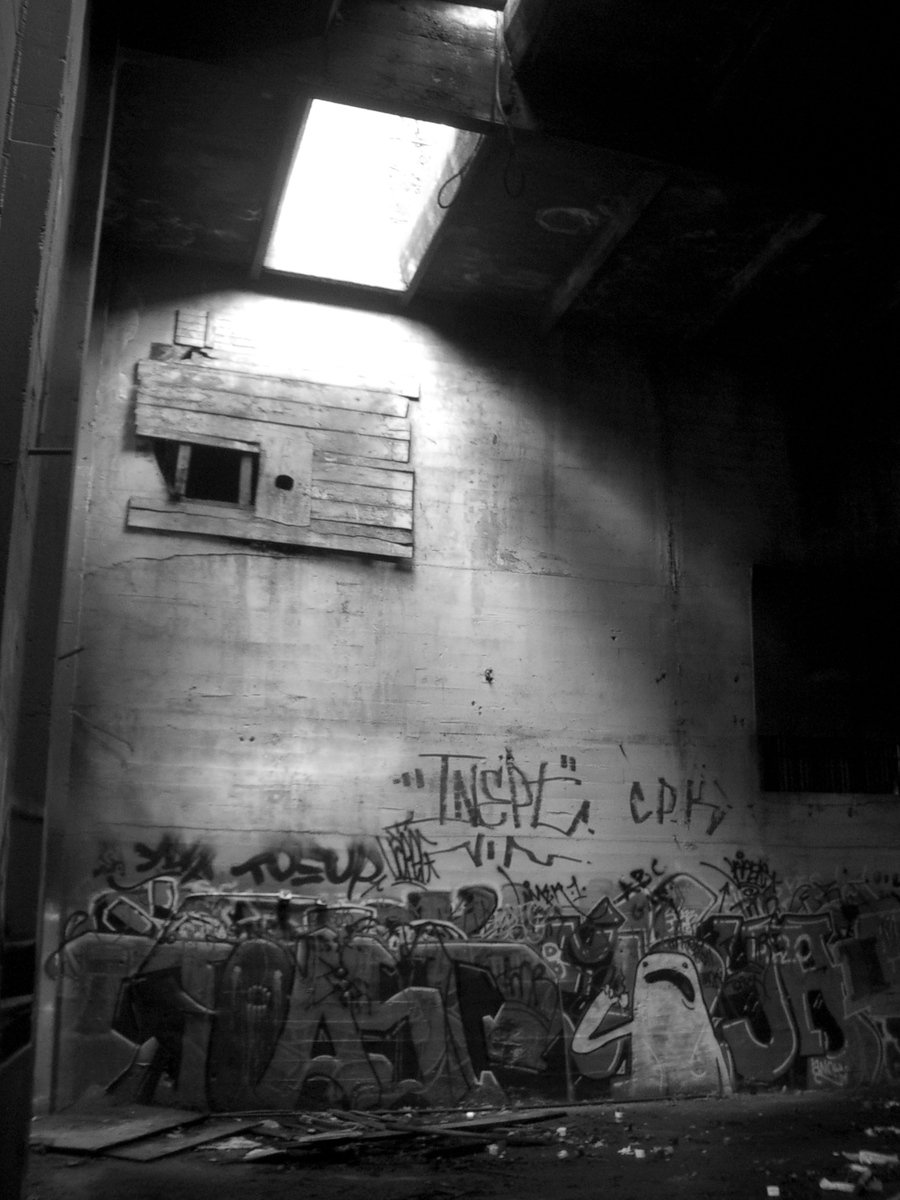 a black and white po of graffiti on the wall of an abandoned building