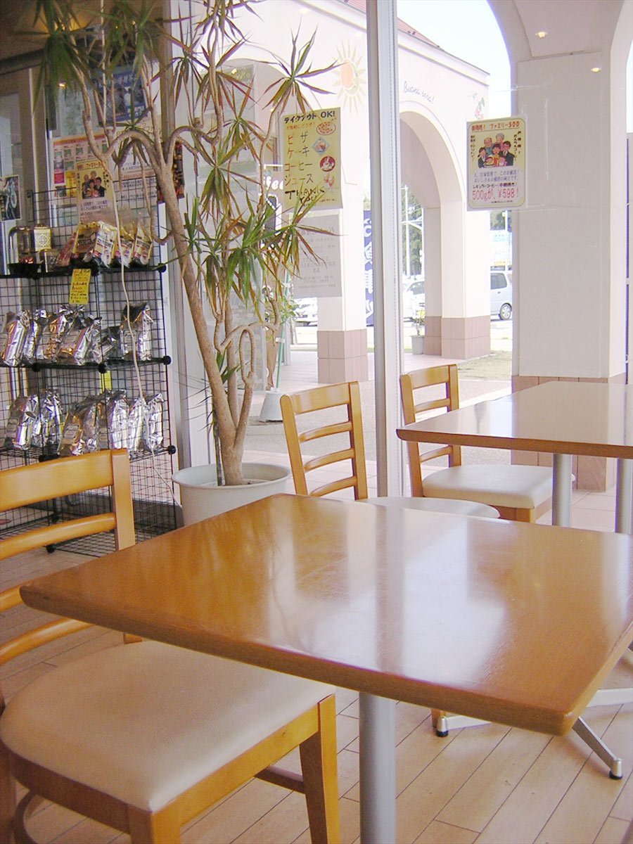 two tables and four chairs in front of a bookcase