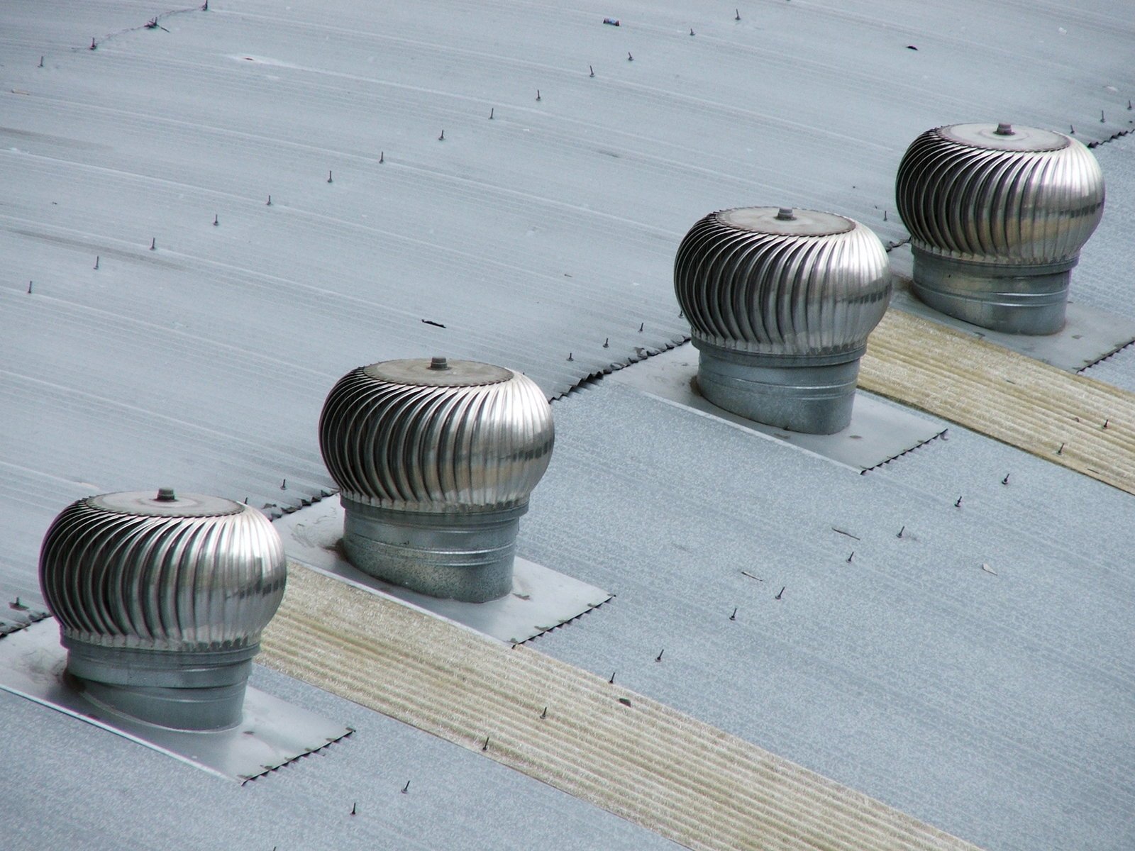 three metallic poles and vents on top of the roof