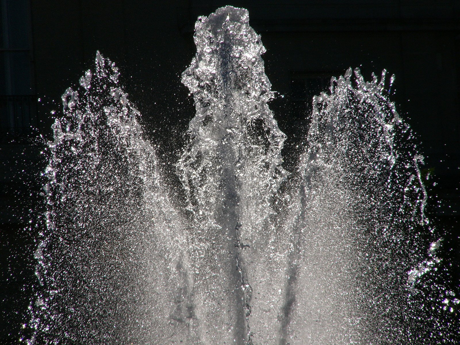 a fountain on the side of the road is spewing water