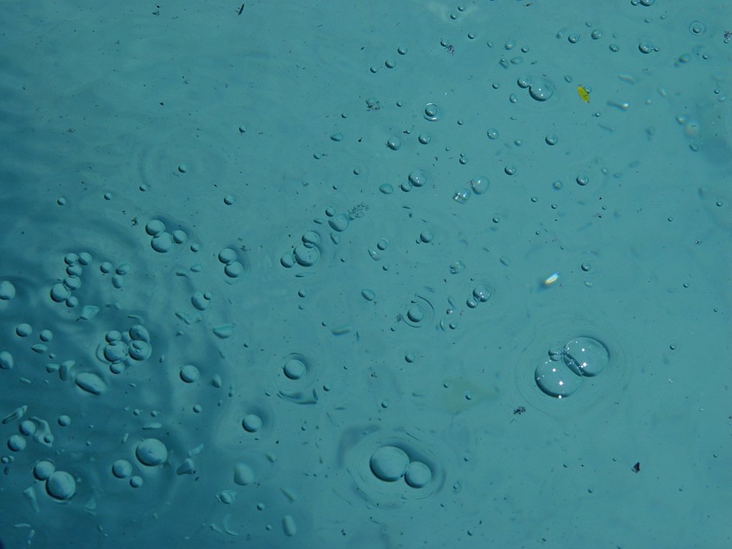 a group of bubbles floating in a large blue water