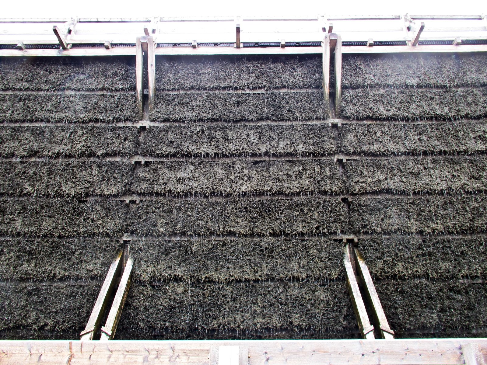 the outside of a building with wood sidings and an aluminum pipe on top