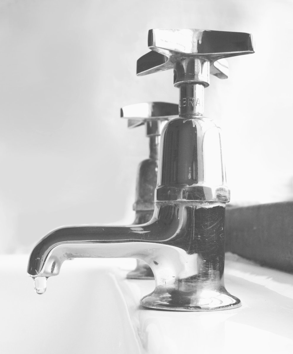 an antique faucet with a water dripping from it