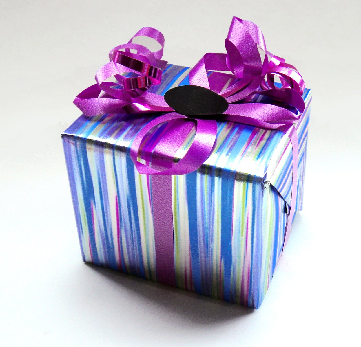 a bright present box is decorated with purple ribbon