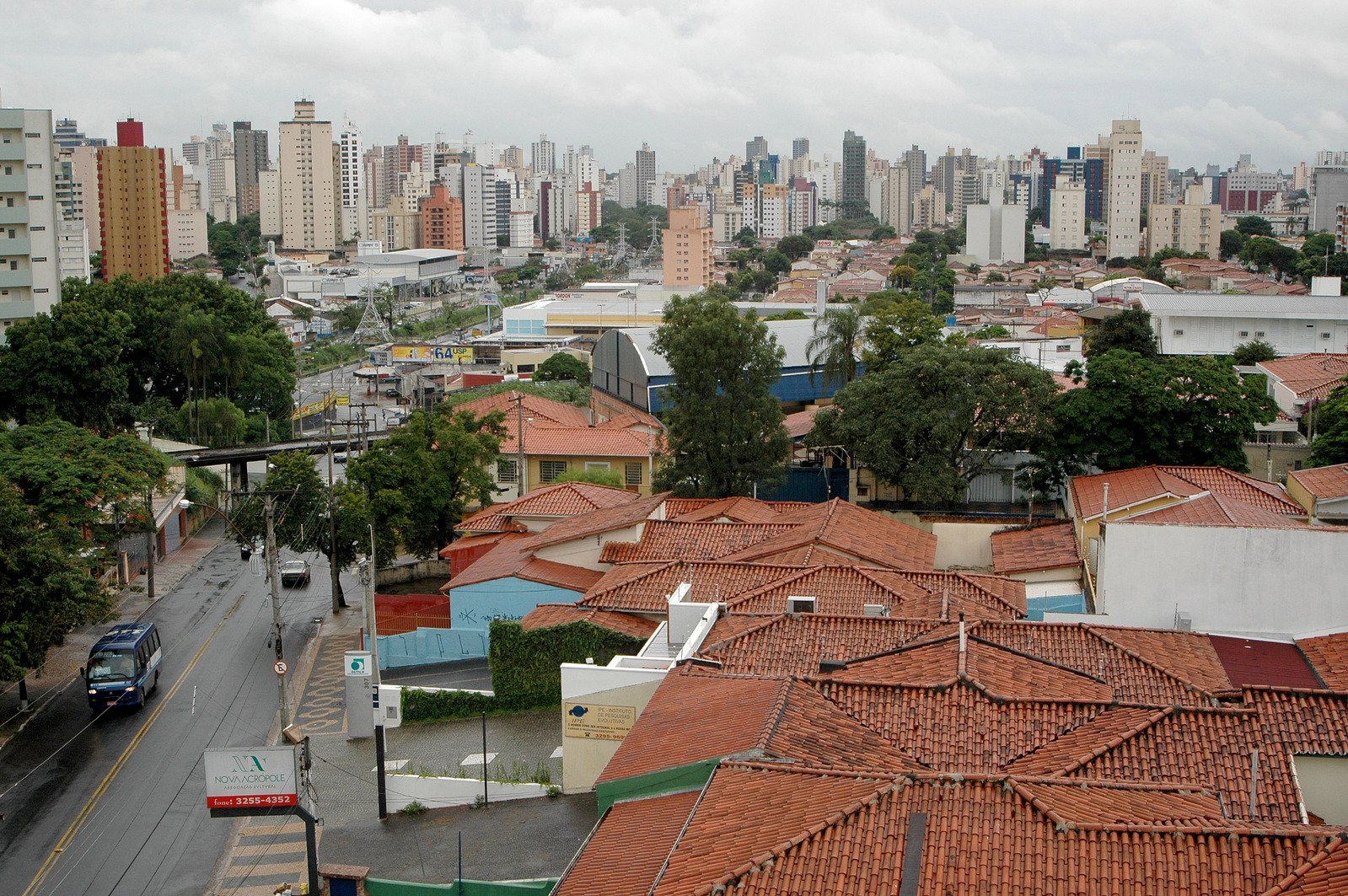 rooftops of residential buildings in the distance with cars parked in front