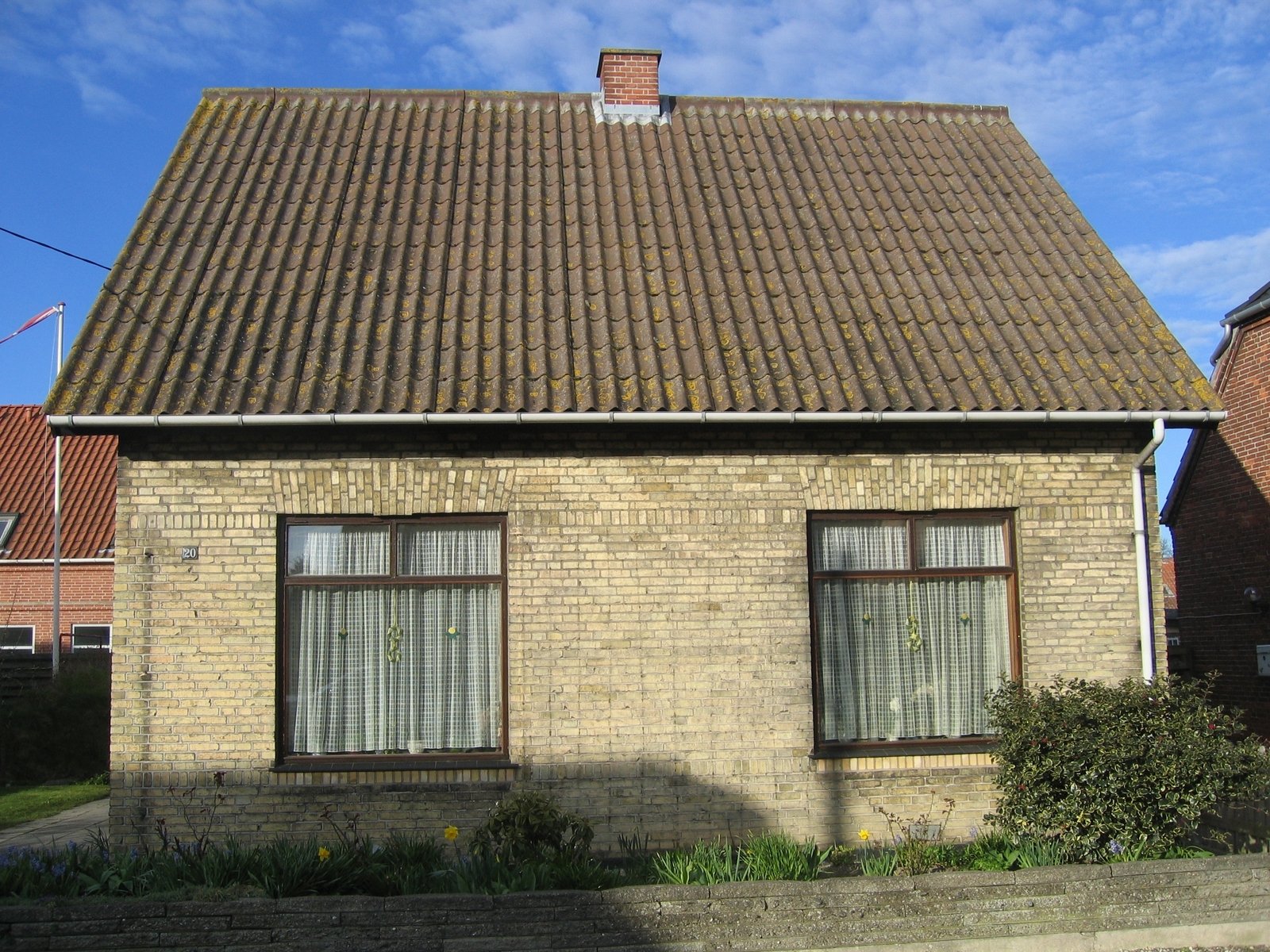 a house with three windows and a brown roof