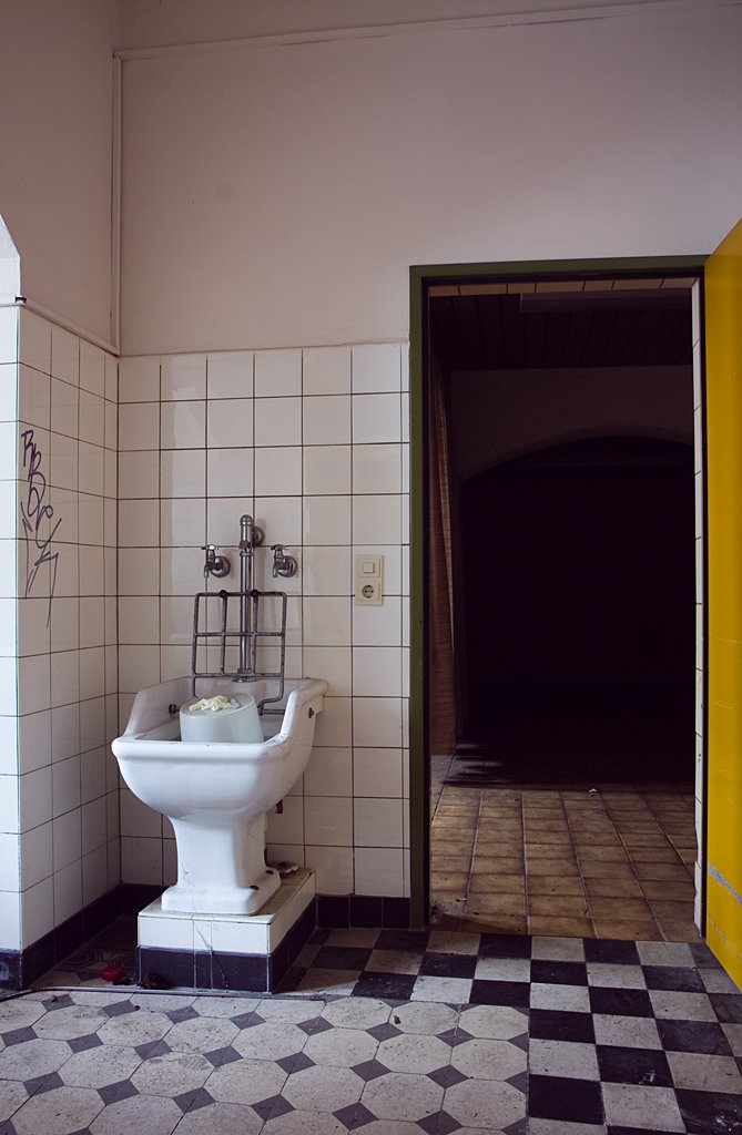 a white toilet in a bathroom next to a checkered floor