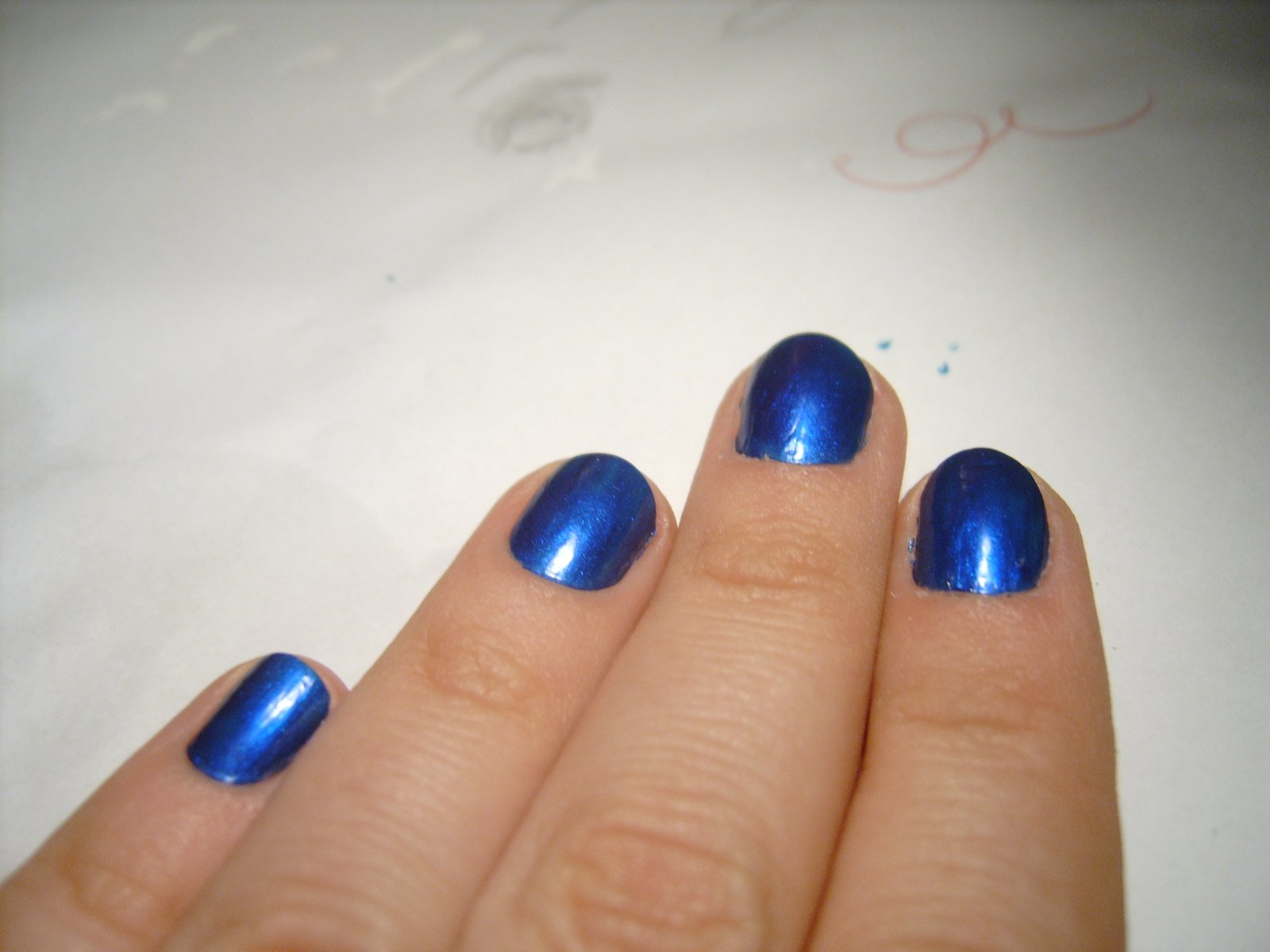 blue nail polish on a woman's finger with silver glitter