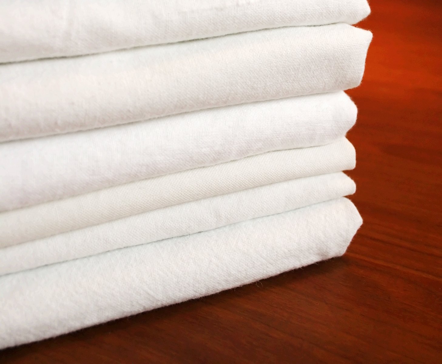 a pile of white towels stacked up on top of each other