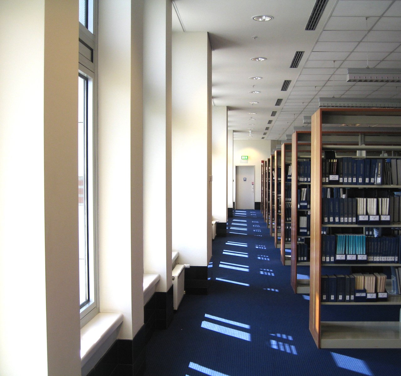 a long corridor is filled with books in the liry