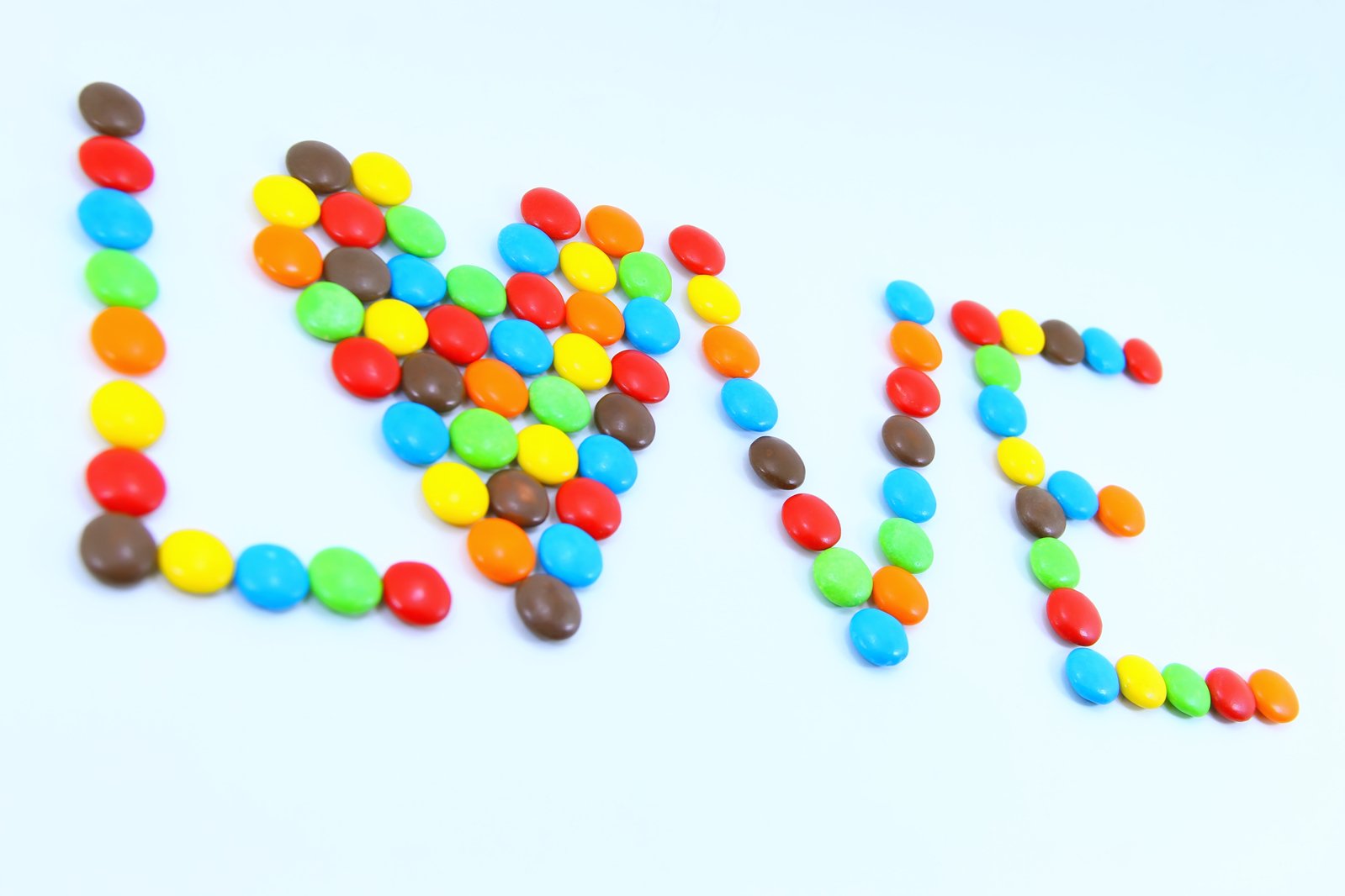 a group of different colored sweets sitting next to the word eat