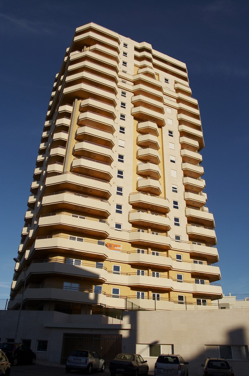 a tall building with balconies in the top part