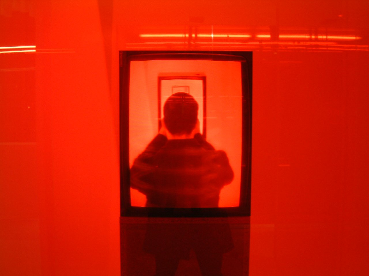 the person is watching in the mirror with the red light from underneath