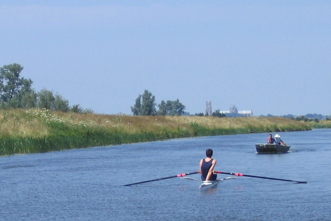 two people rowing on their canoes in the middle of a body of water