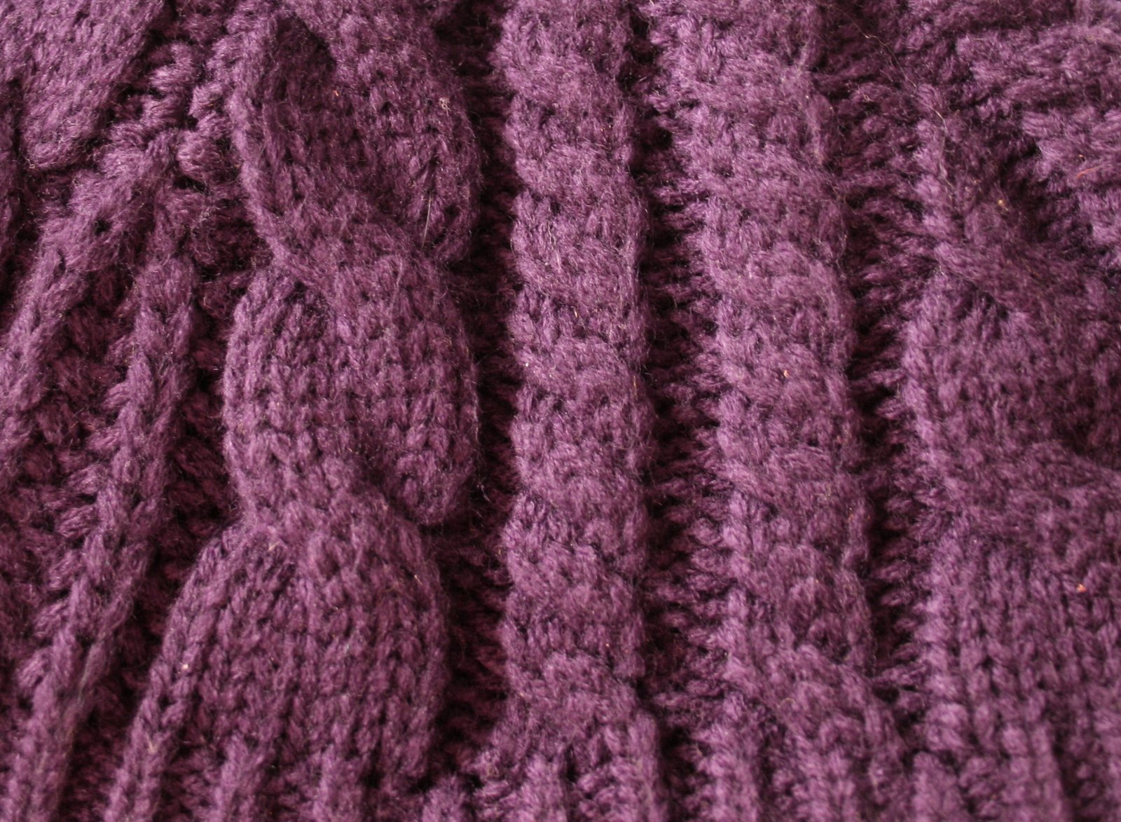 purple knitted fabric with intricate stitches made by a young person