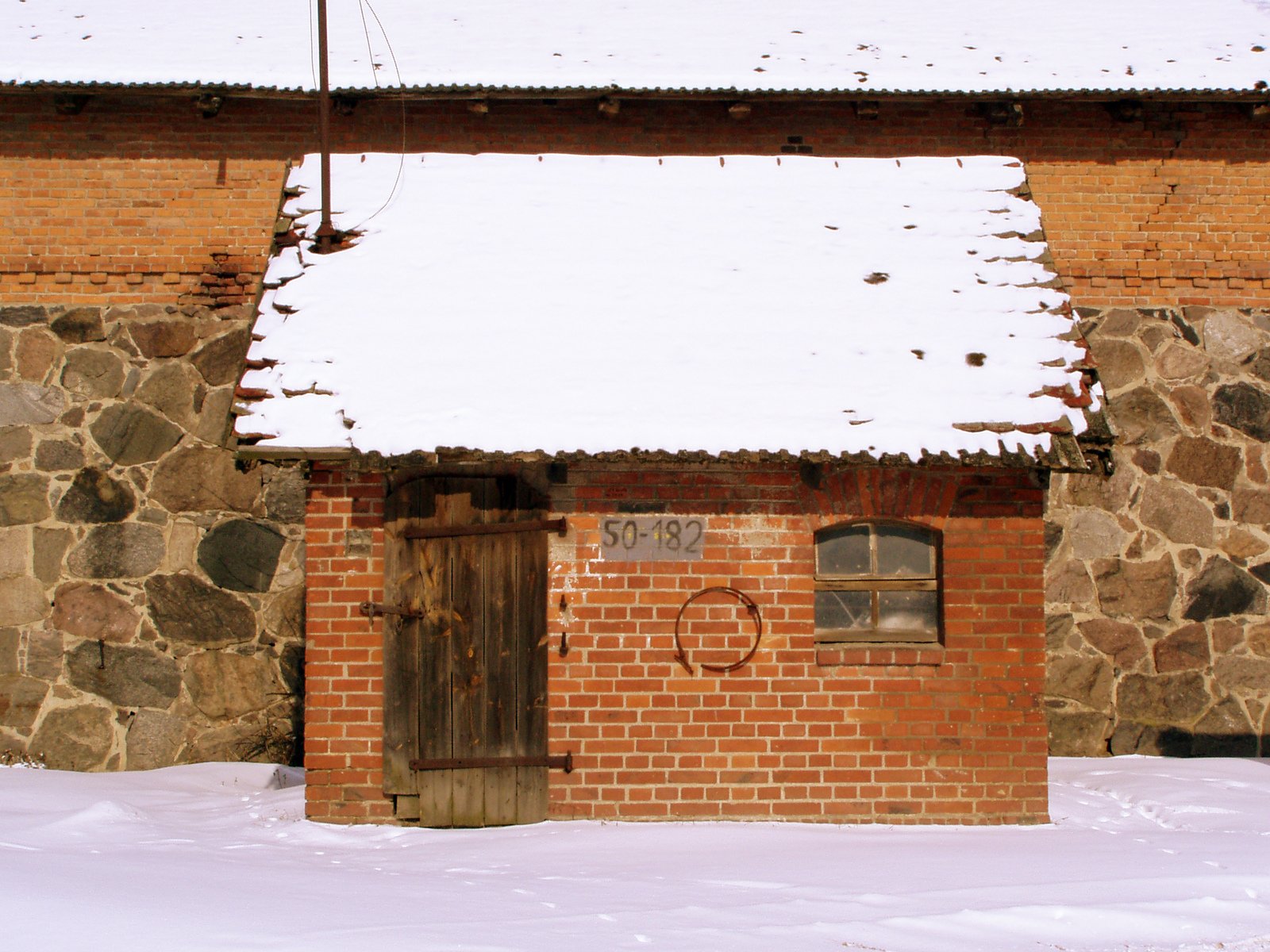 a red brick building with white snow on it