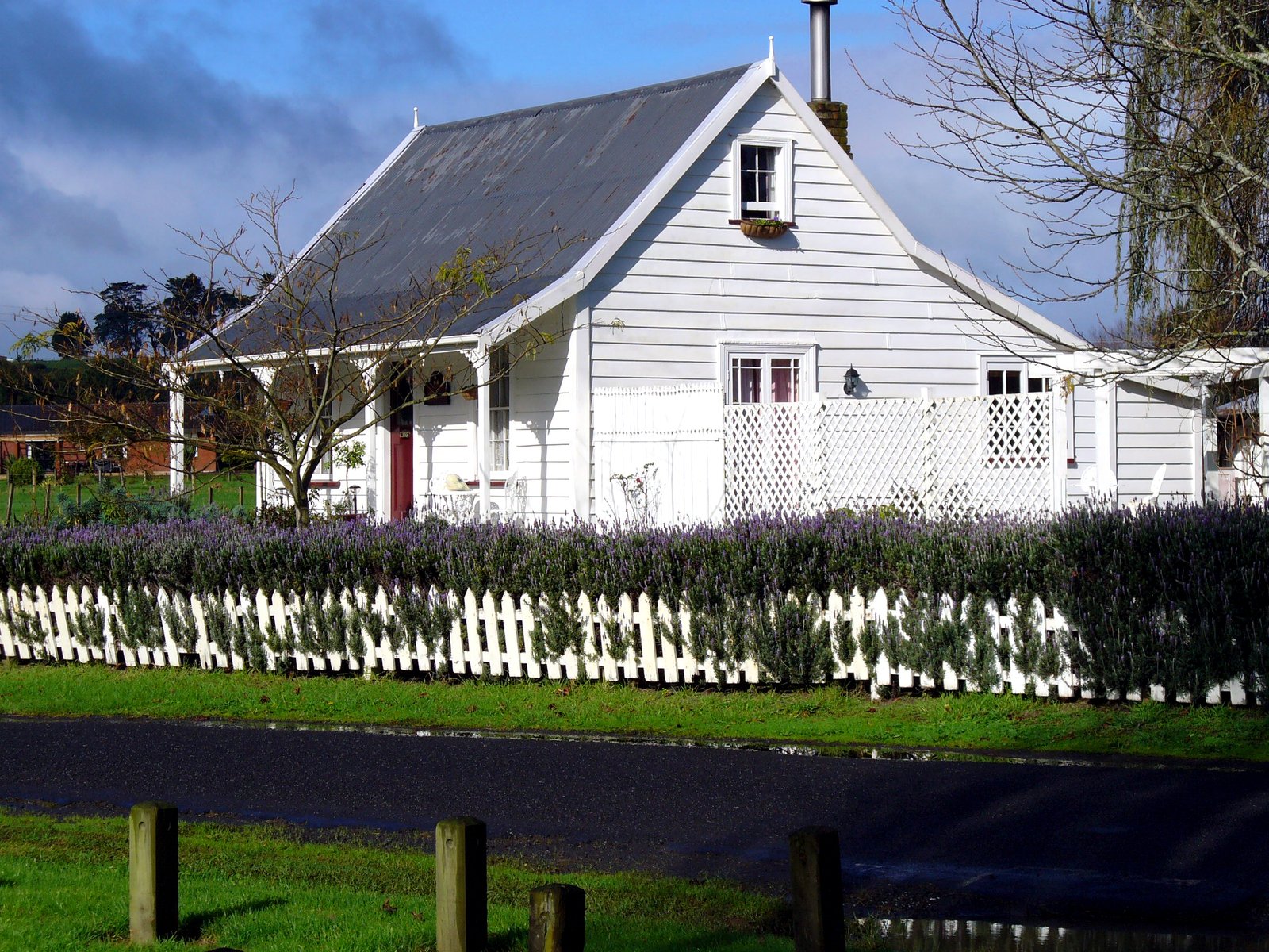 a small white house sitting on a lush green lawn