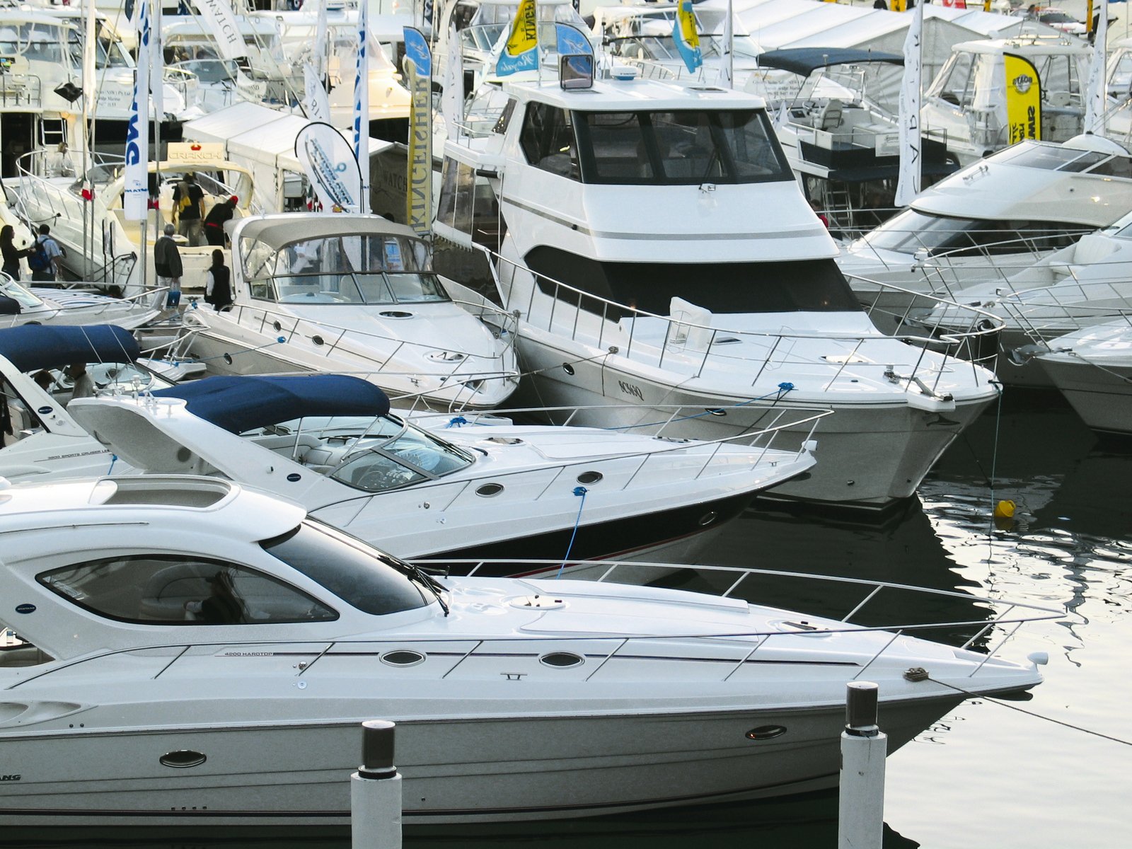 many boats and some people standing on the dock