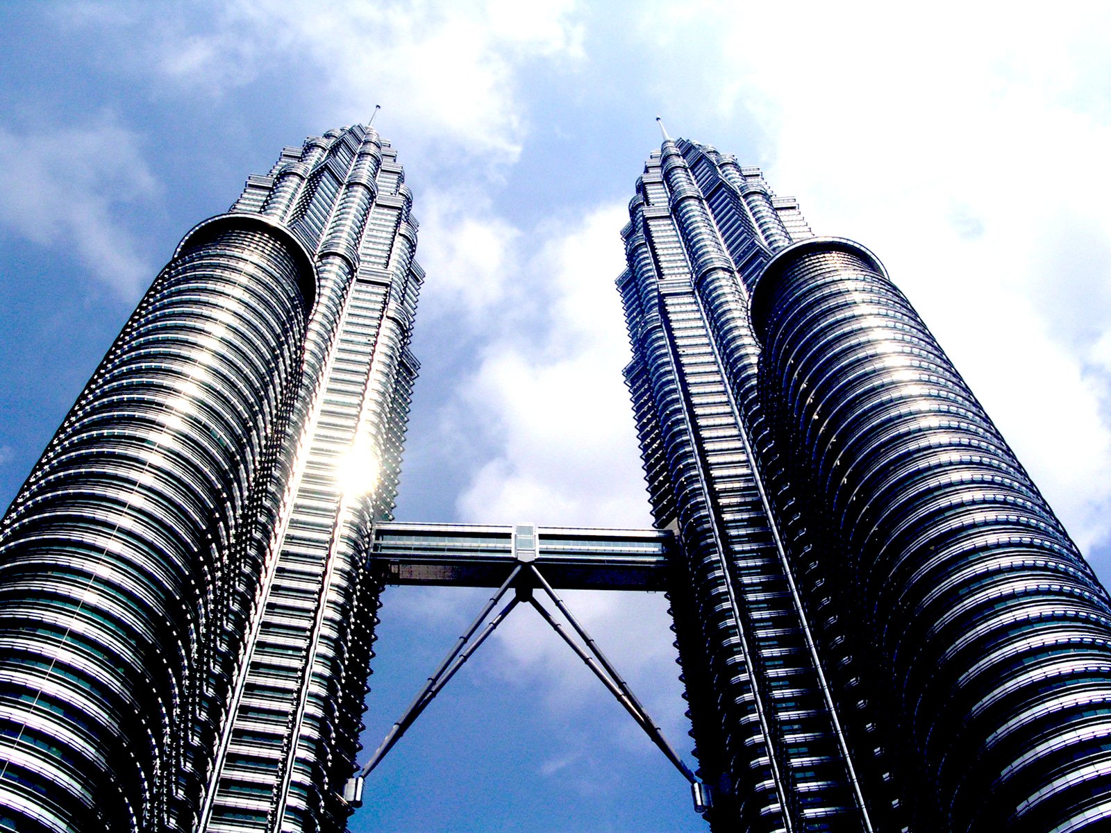 two very tall buildings stand in front of a blue sky