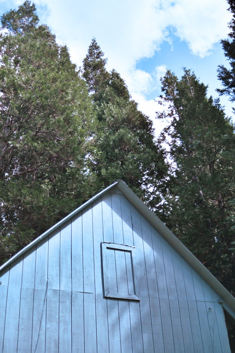 there is a blue barn that has a window on it