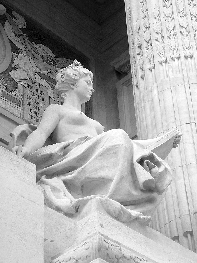 a statue of a woman that is holding a book