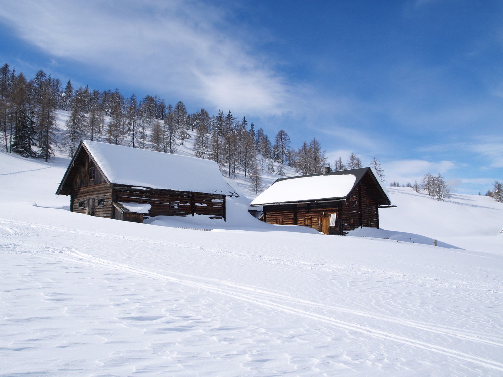 a snowy landscape with two barns near by