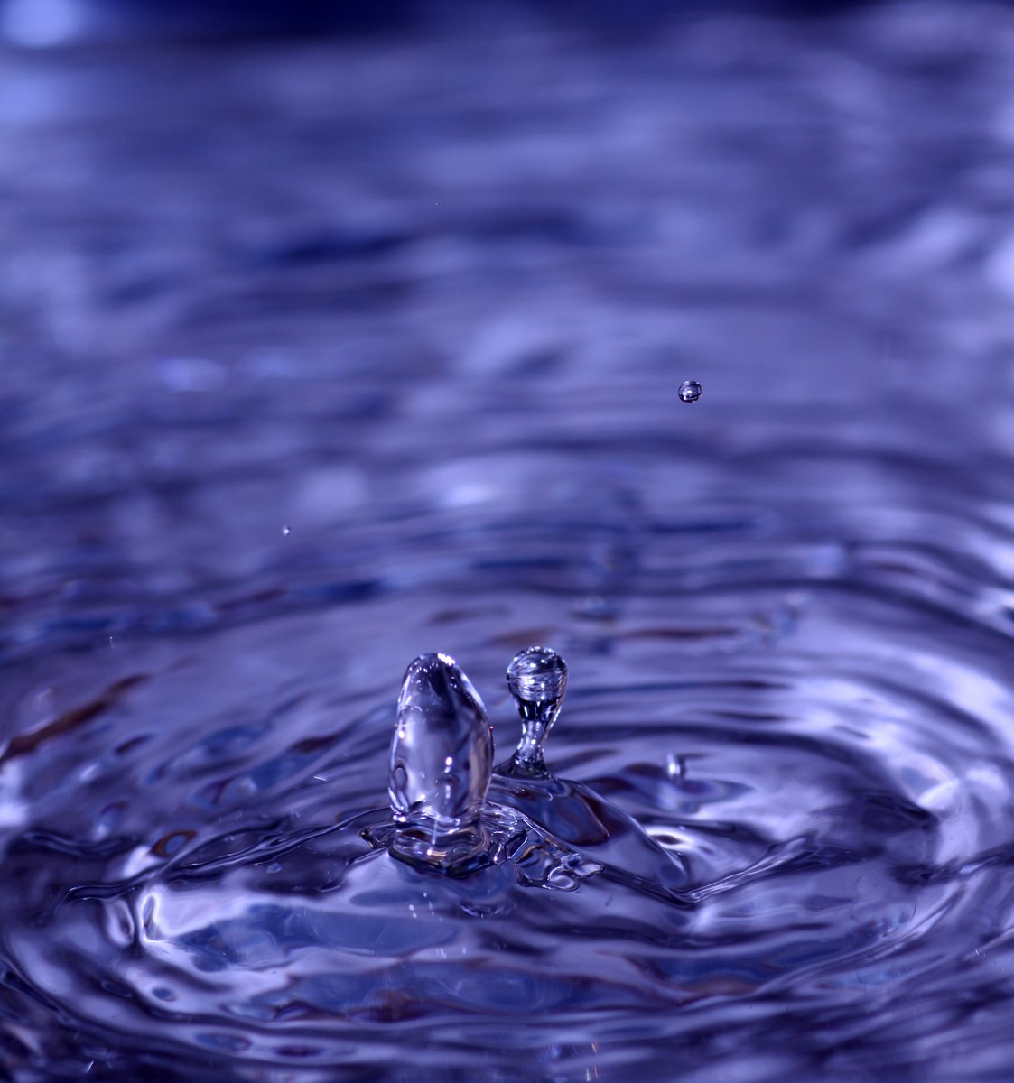 a blue water with a drop of water near the top