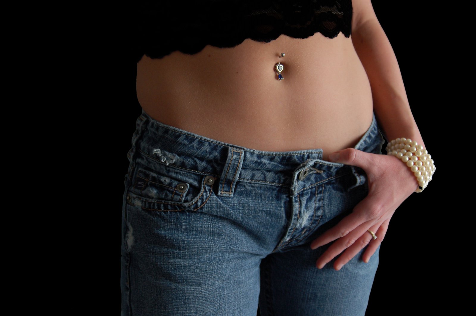 woman wearing belt and jeans with gold jewelry