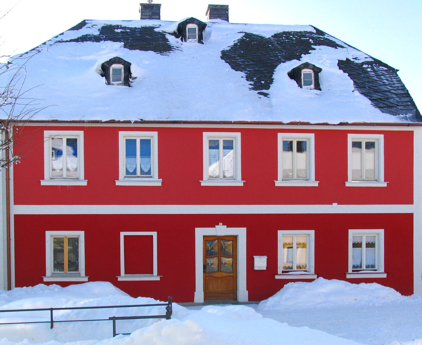 a red house with snow covering the ground