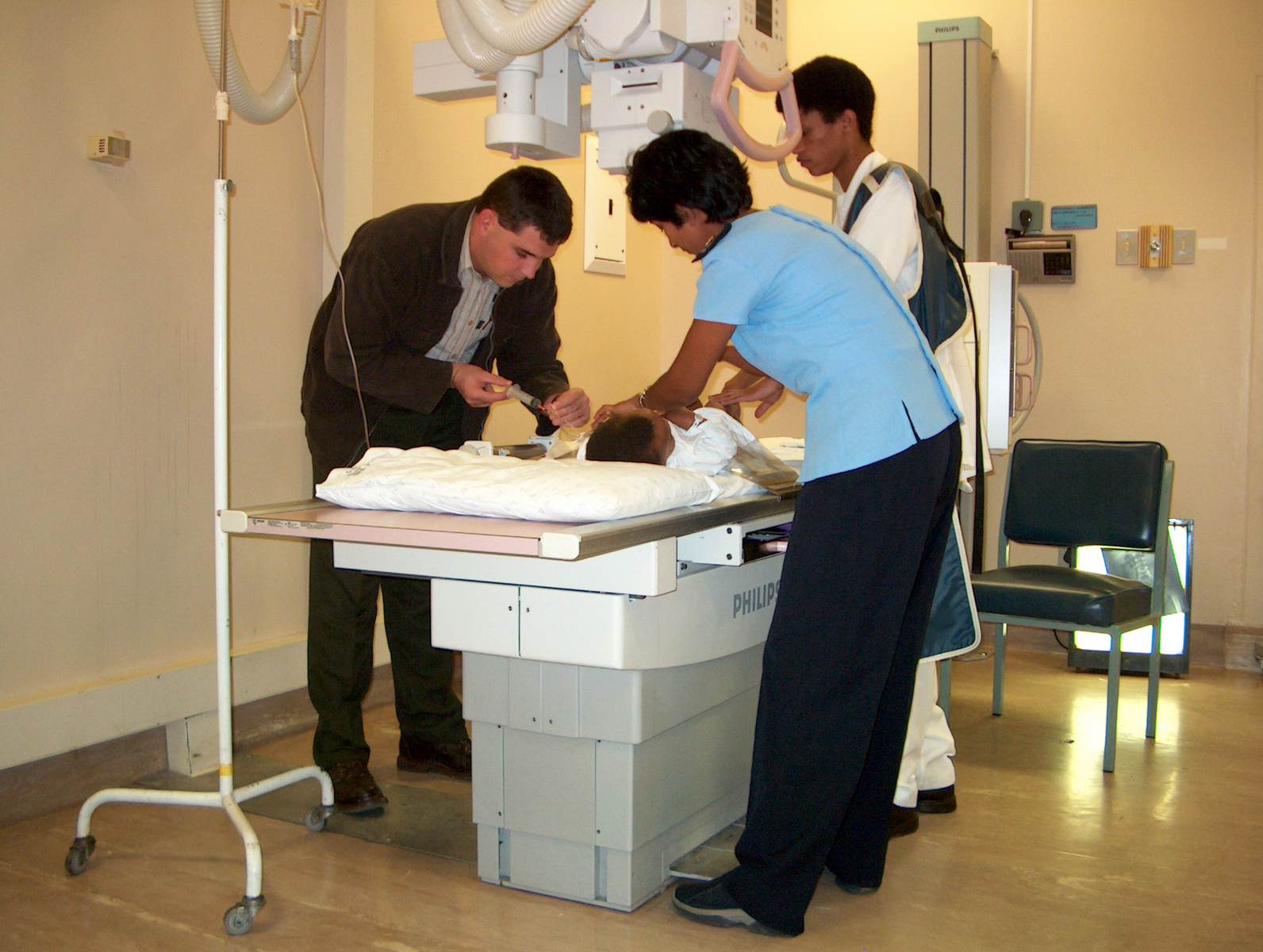 a hospital room with three people and a baby