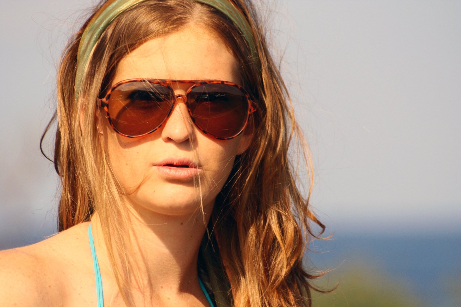 a girl wearing sunglasses and a hairband