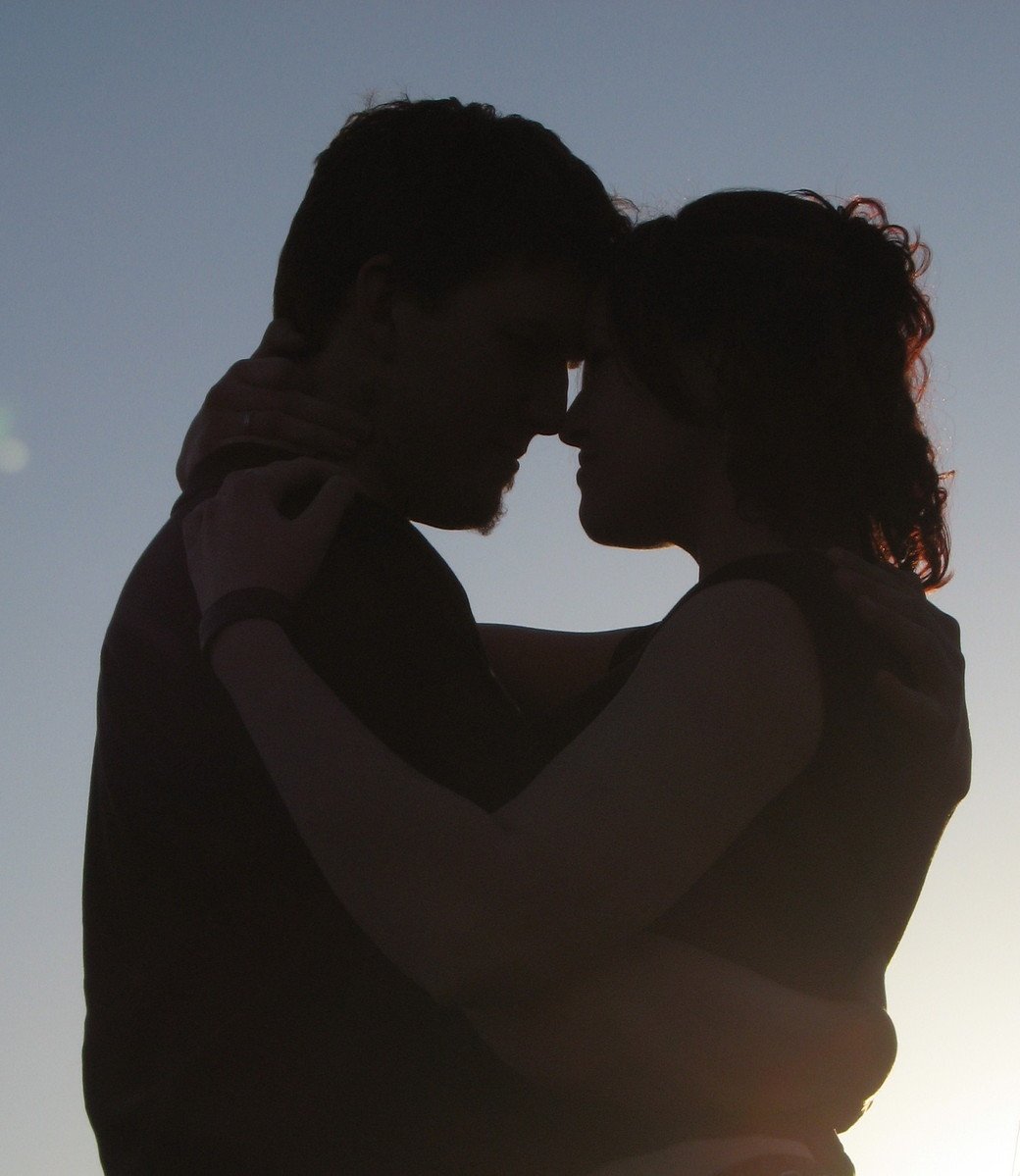 man and woman facing each other with their arms around each other