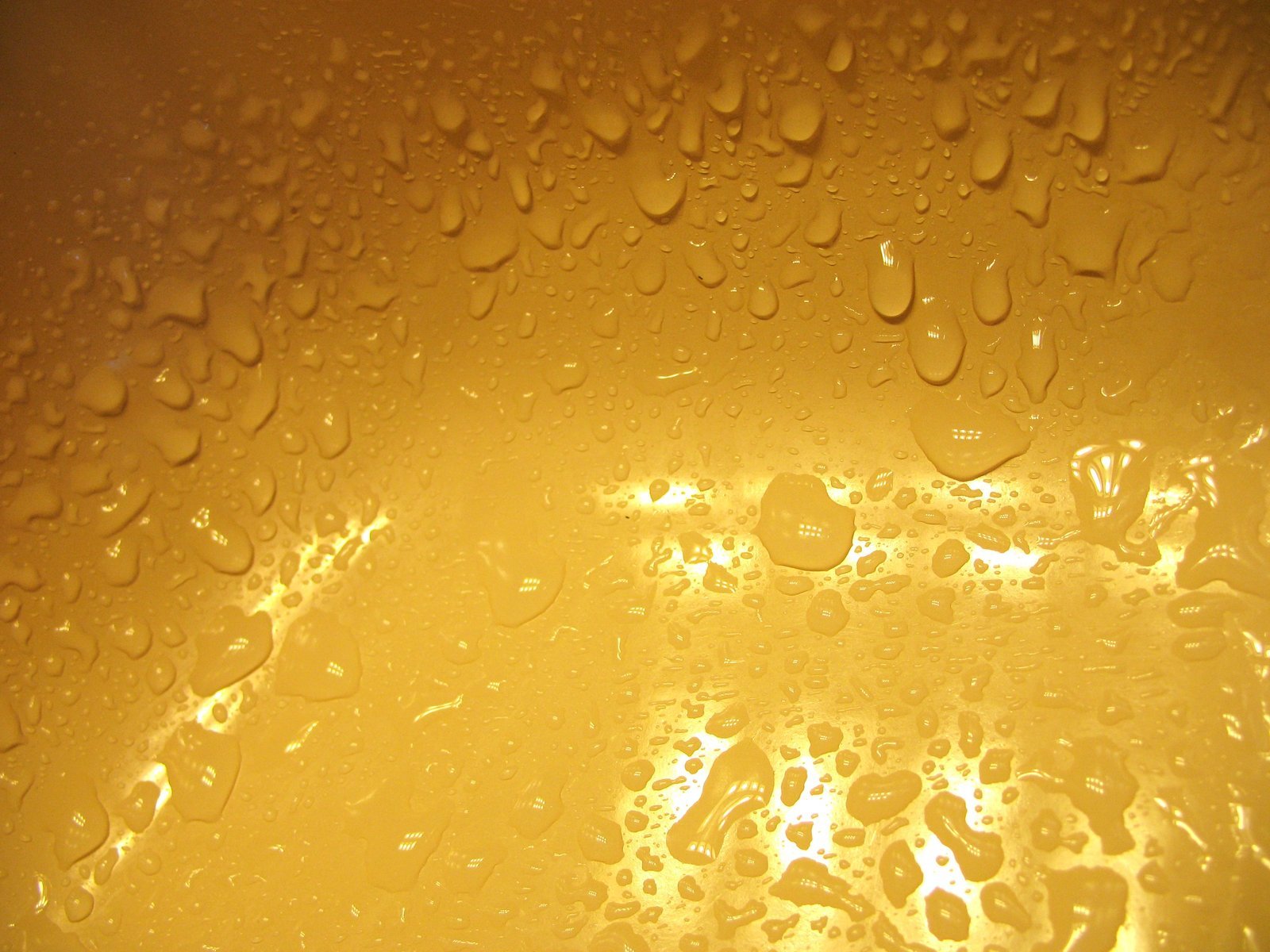 an extreme close up view of yellow bubbles on water