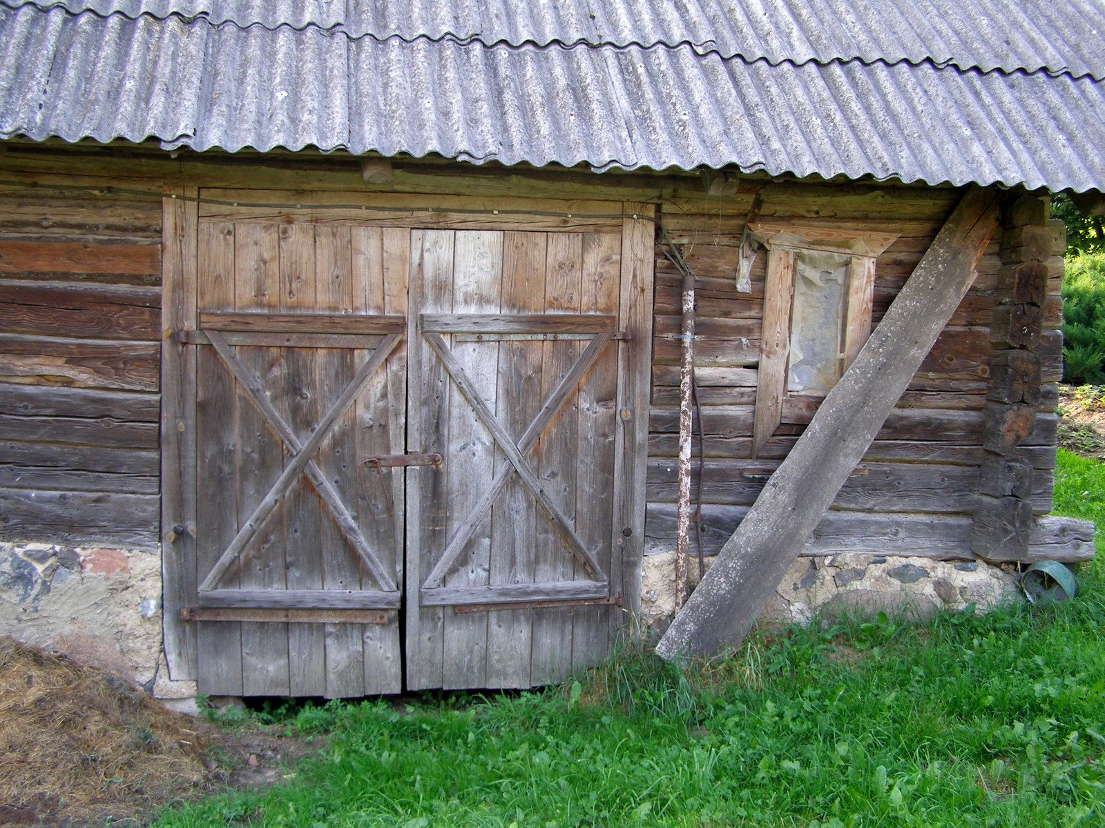 a shed with a metal roof and open wooden doors