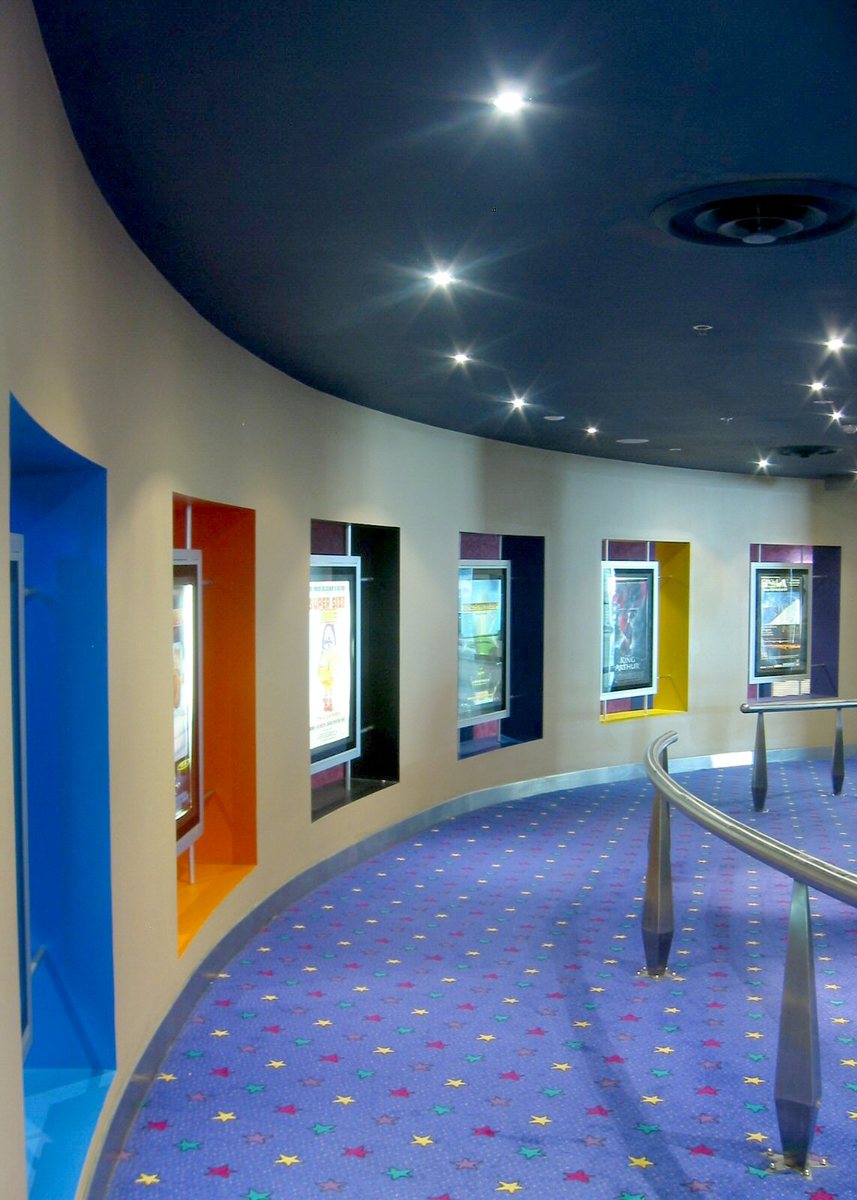 a room with several different colored windows and circular carpet
