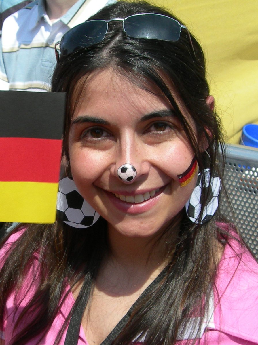 a woman wearing sunglasses and with a soccer ball painted on her face