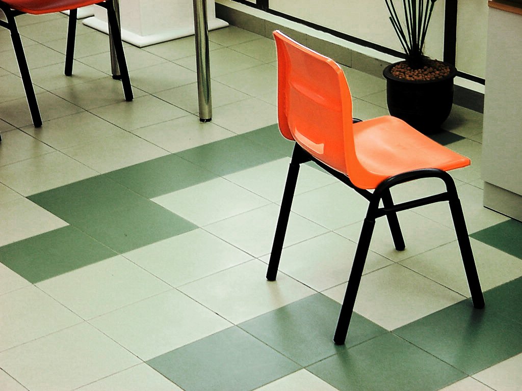 the orange chairs are placed on the checkered floor