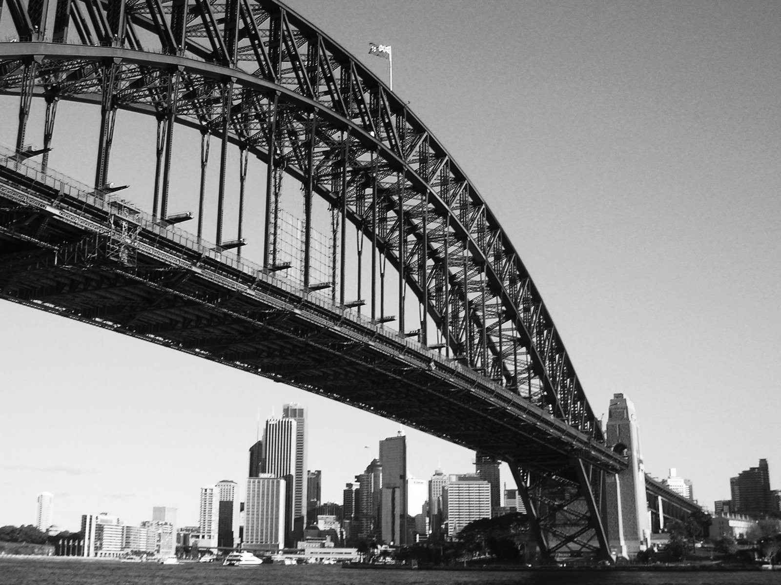 the skyline of sydney, australia is seen through the under bridge