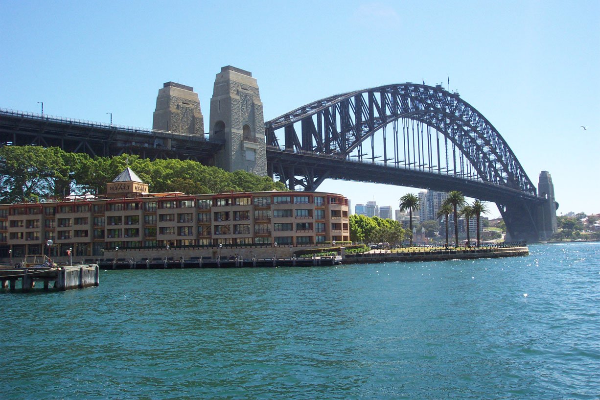 a boat moving along the river past a bridge