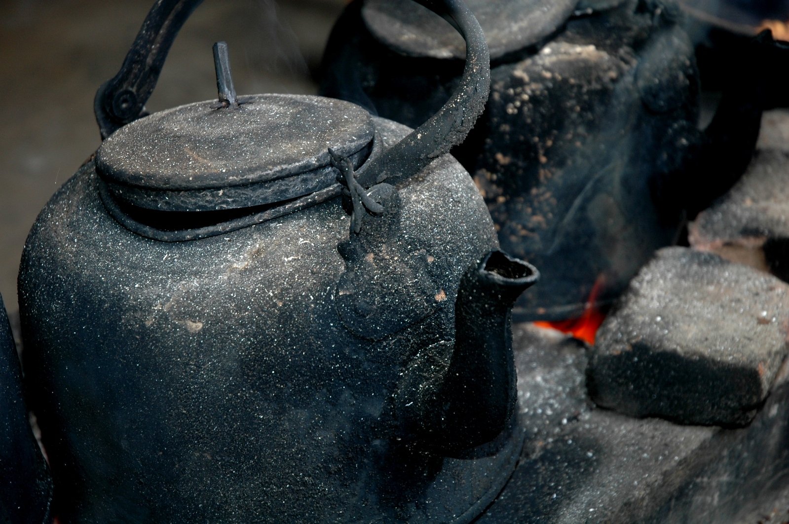 old black kettles and tea kettles with flames coming out of them