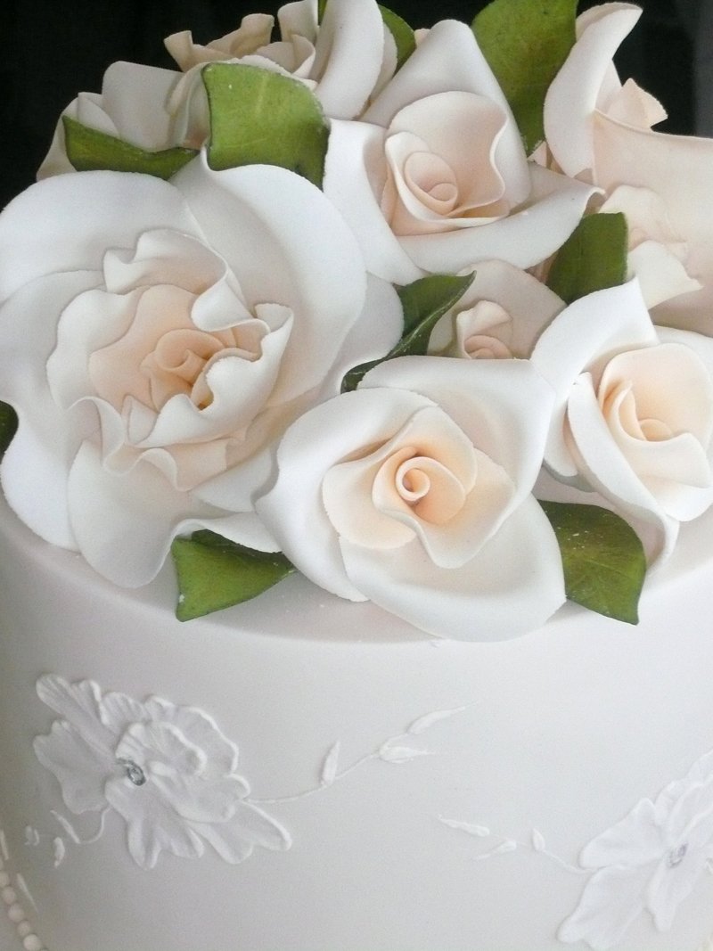 there is an elaborate white frosted cake with flowers