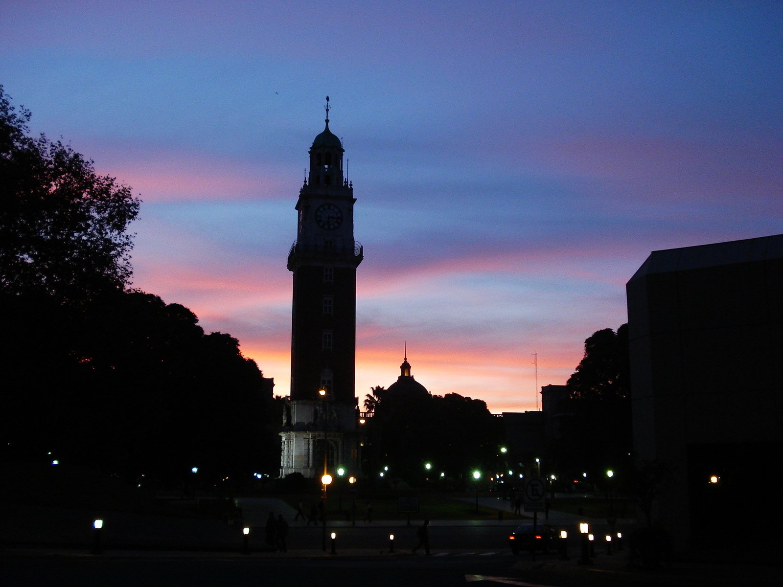 a tower with some people and a sunset behind it