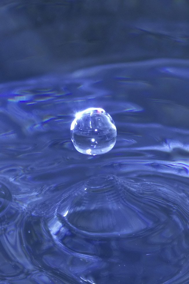 a blue water droplet with blue ripples on top