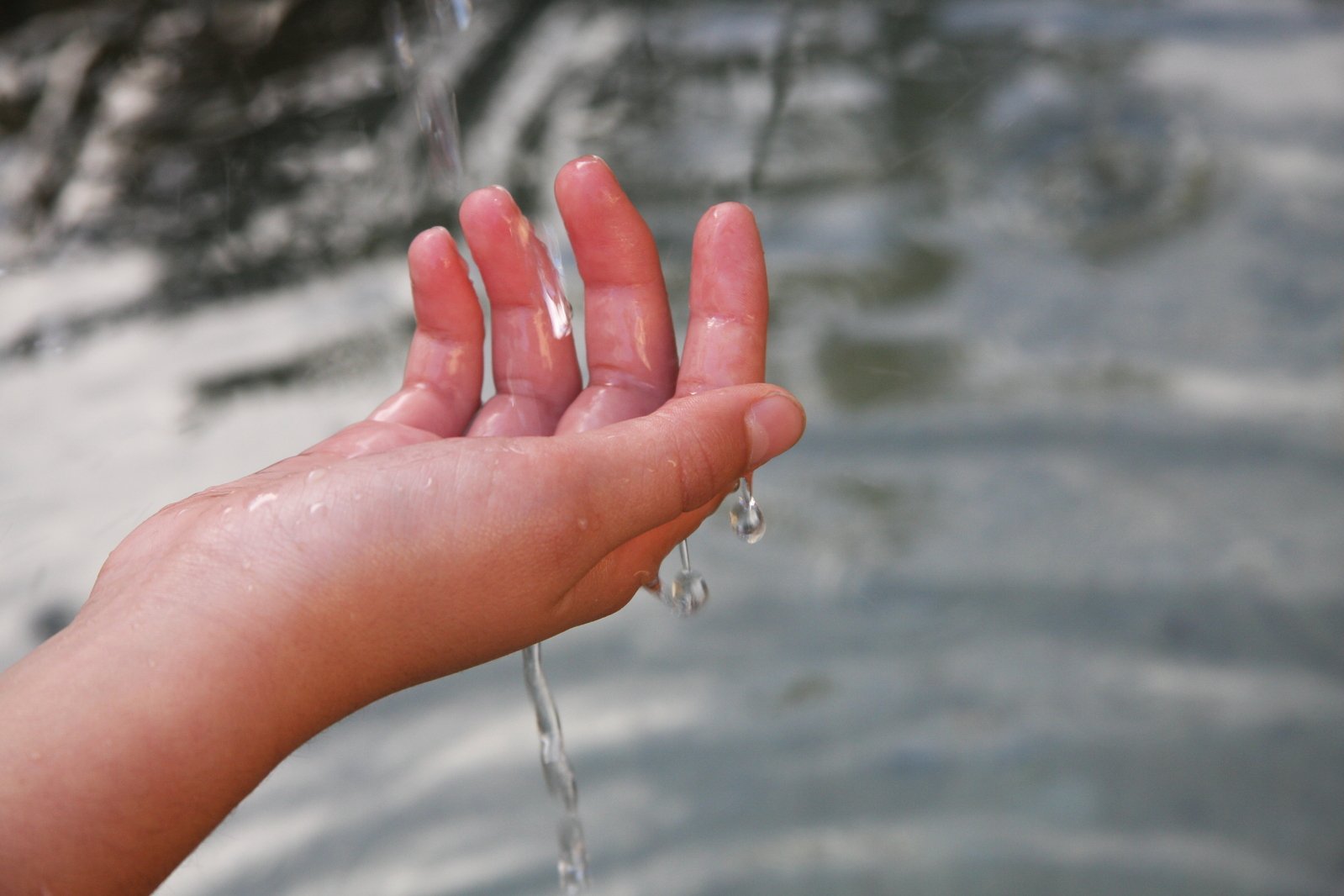 a person is holding their hand out and holding the water