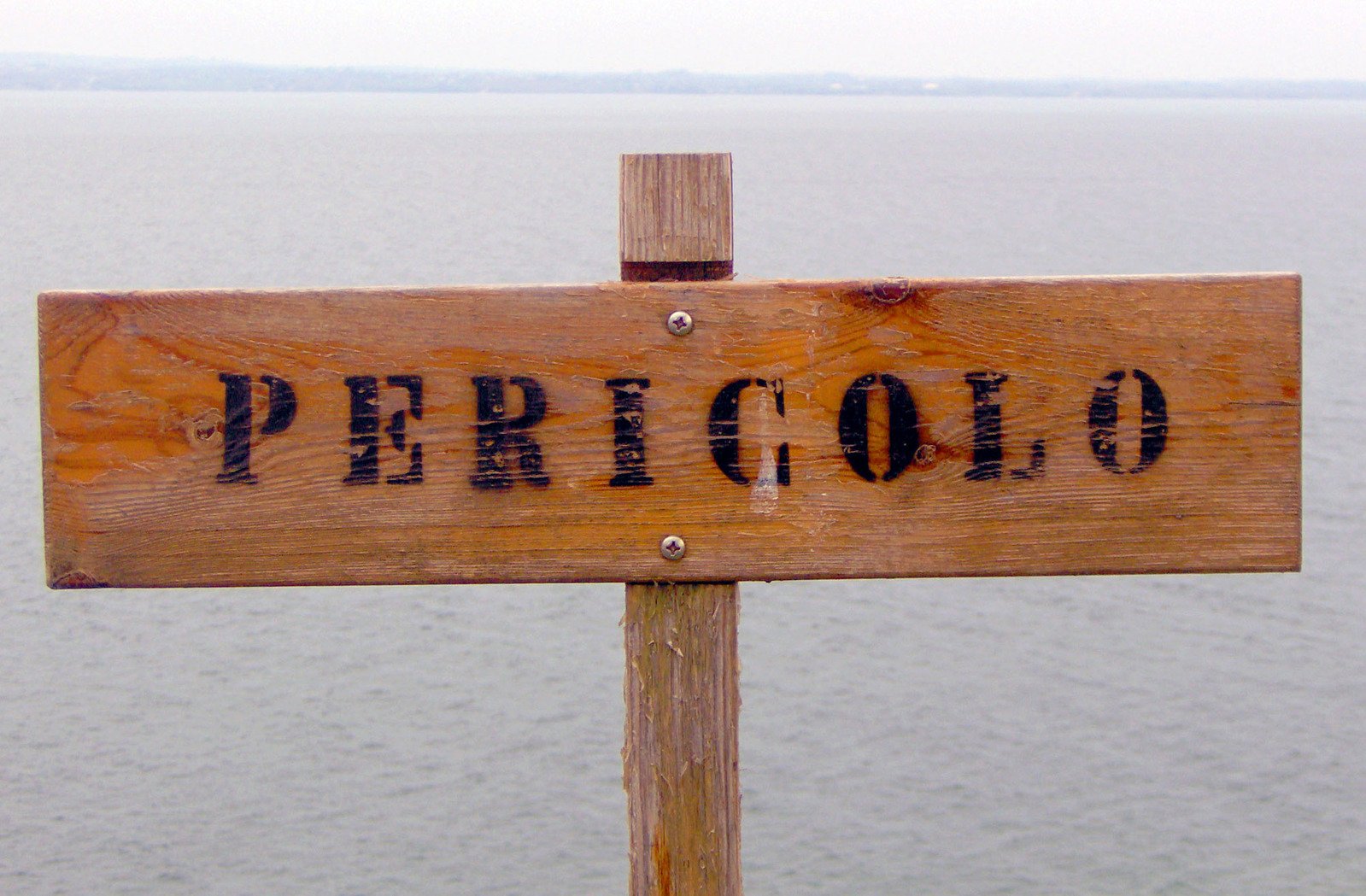 a sign points the direction to pericolo