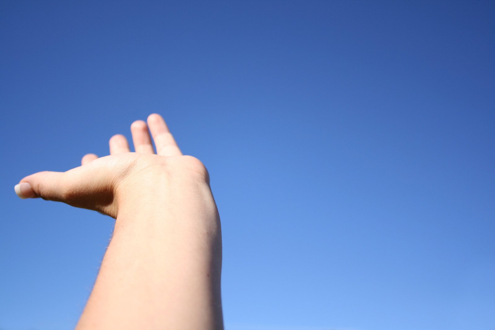 someone holding out their hand with the sky background