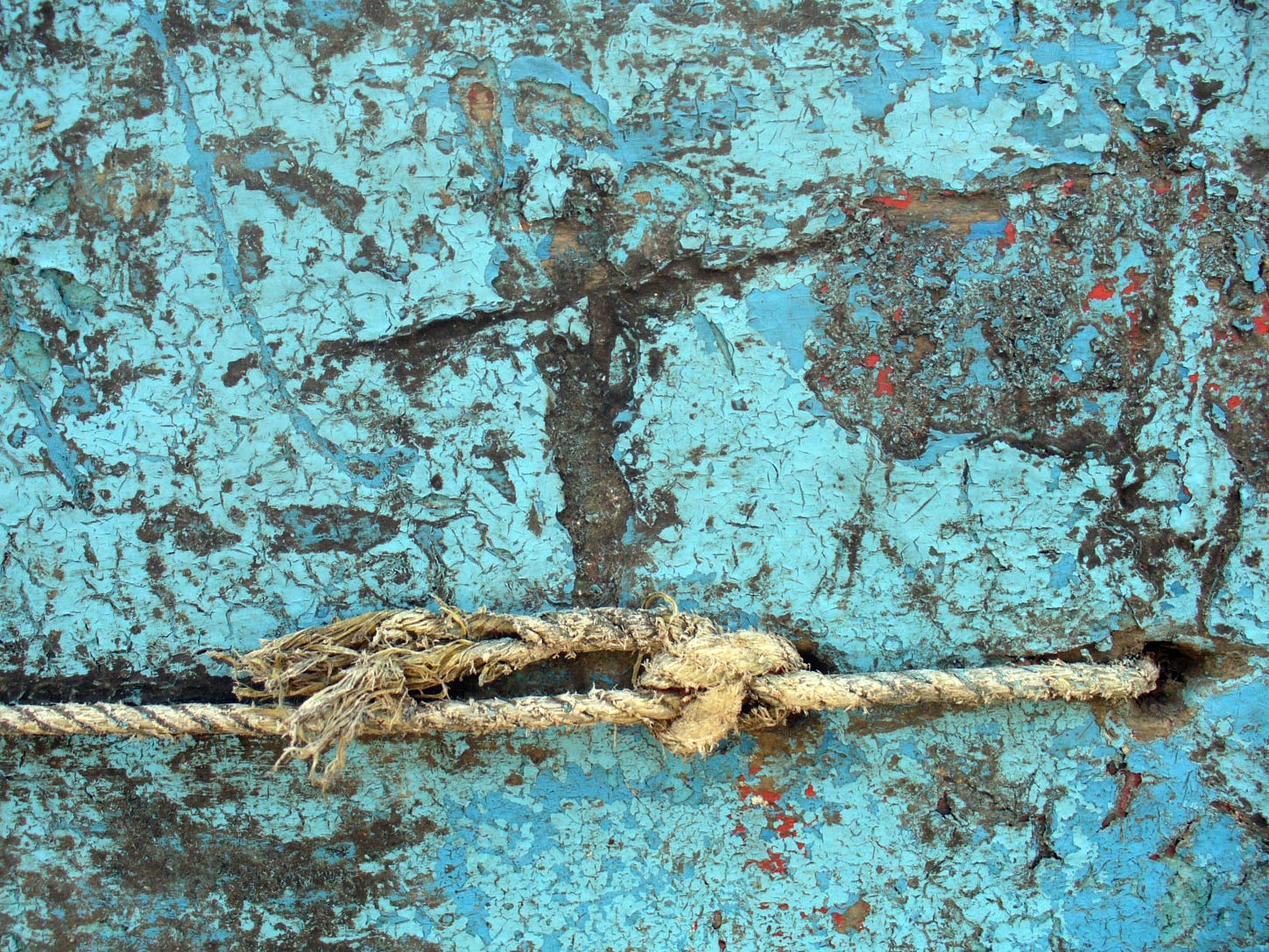 ropes are hanging on a blue weathered wall