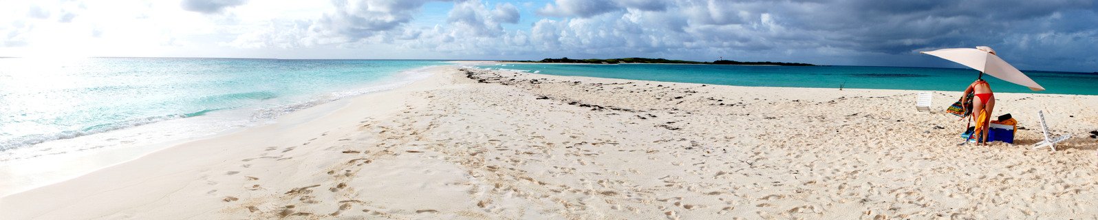 people standing on the white sand at a beach