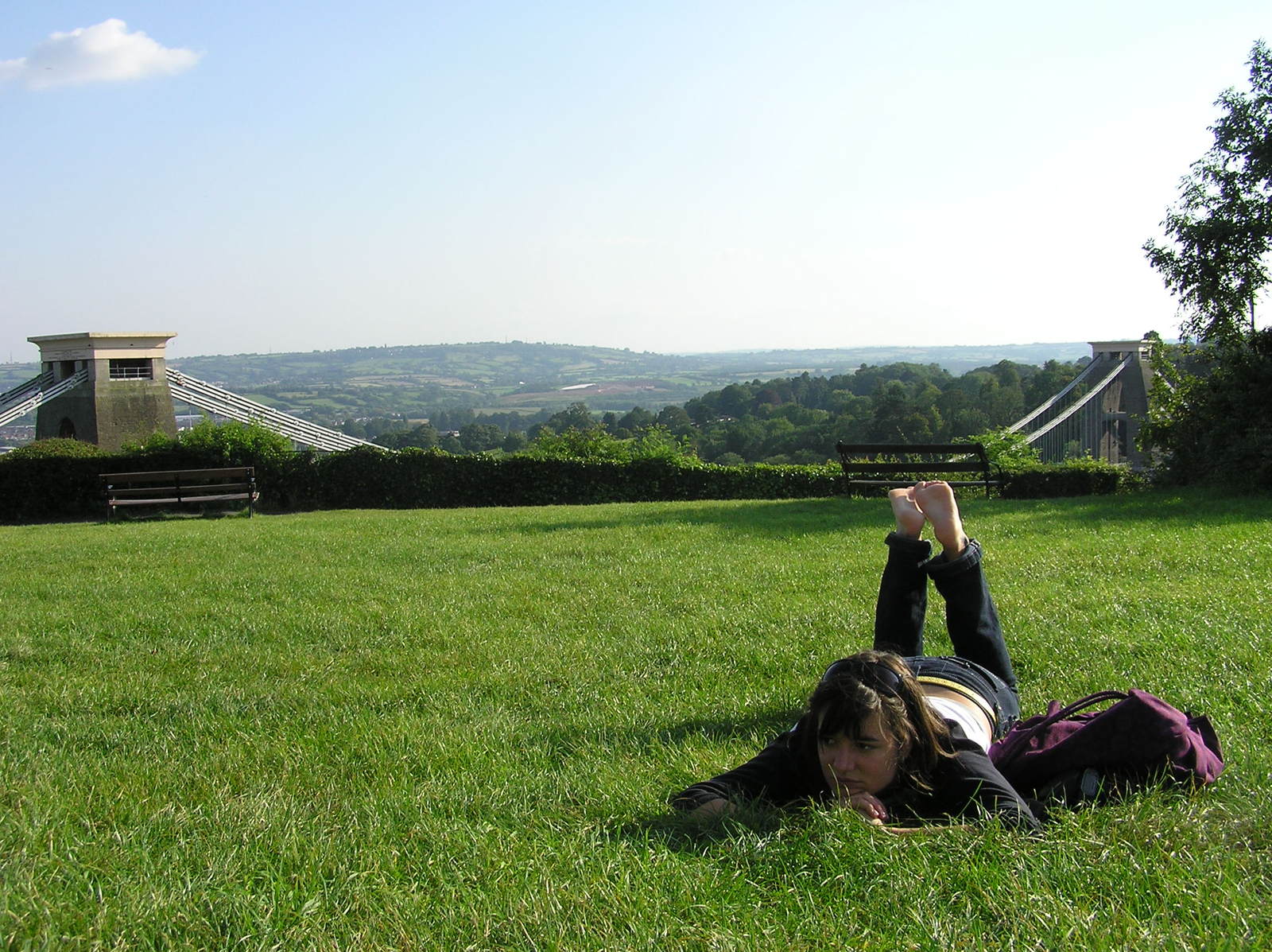 girl laying in the grass reading a book